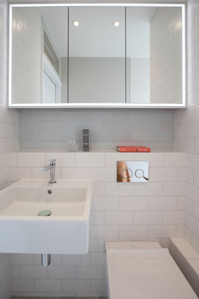 Modern inredning av ett litet vit vitt badrum med dusch, med vit kakel, keramikplattor och kaklad bänkskiva