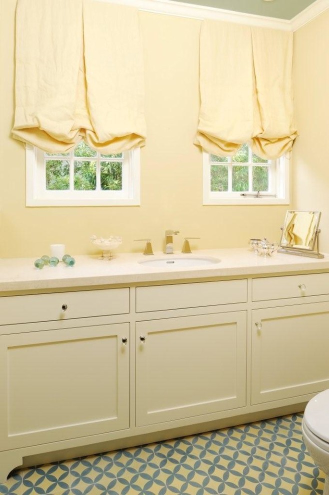 Inspiration pour une petite salle d'eau traditionnelle avec un lavabo encastré, un placard à porte shaker, des portes de placard beiges, un plan de toilette en calcaire, une douche d'angle, WC à poser, un mur jaune, sol en béton ciré, un carrelage beige et des carreaux de céramique.