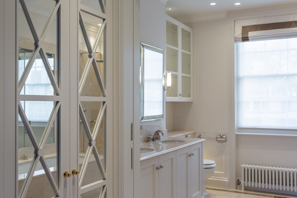 Imagen de cuarto de baño principal minimalista de tamaño medio con lavabo integrado, encimera de mármol, bañera encastrada, ducha esquinera, sanitario de una pieza, paredes blancas y suelo de mármol