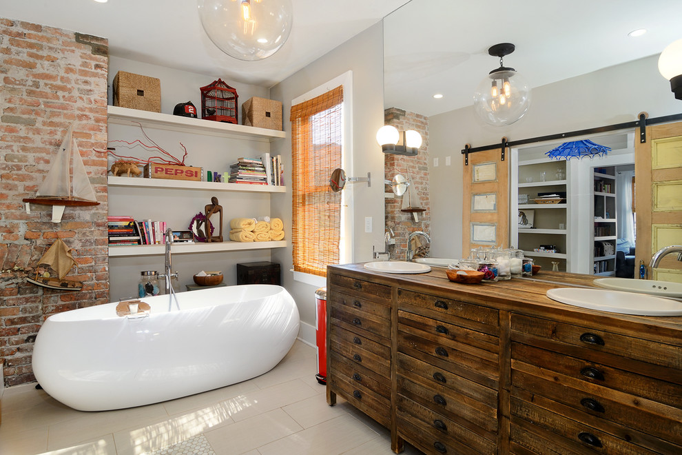 На фото: ванная комната в стиле фьюжн с накладной раковиной, темными деревянными фасадами, столешницей из дерева, отдельно стоящей ванной, бежевой плиткой, бежевыми стенами, коричневой столешницей и плоскими фасадами