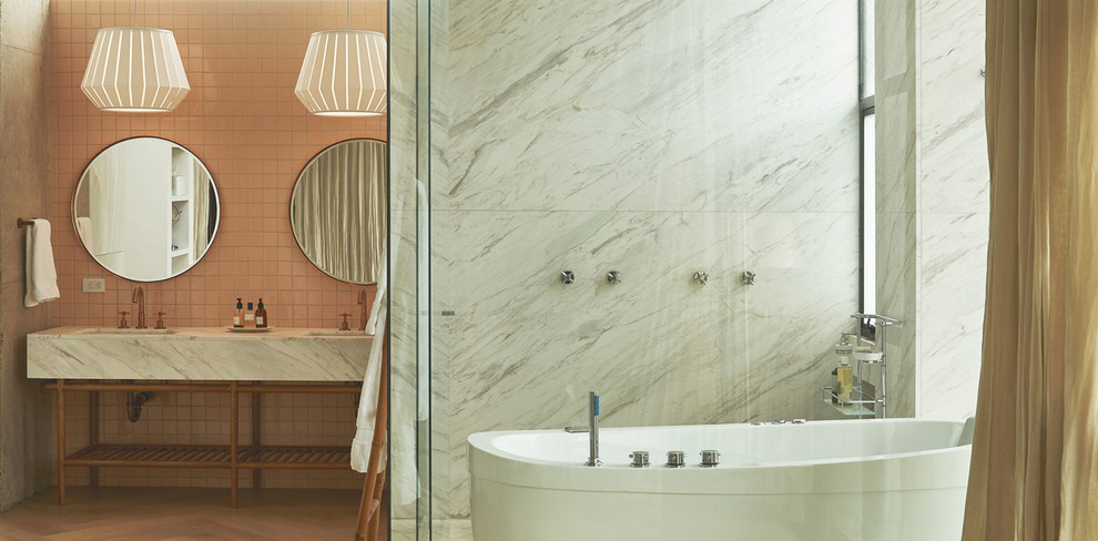 Inspiration för stora 60 tals grått en-suite badrum, med ett fristående badkar, en dusch/badkar-kombination, rosa kakel, keramikplattor, rosa väggar, mellanmörkt trägolv, ett nedsänkt handfat, brunt golv och dusch med gångjärnsdörr