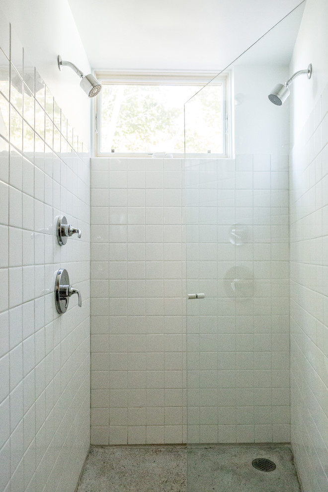 Modelo de cuarto de baño principal actual pequeño con ducha doble, baldosas y/o azulejos blancos, baldosas y/o azulejos de cemento, paredes blancas, suelo de cemento, suelo gris y ducha con puerta con bisagras