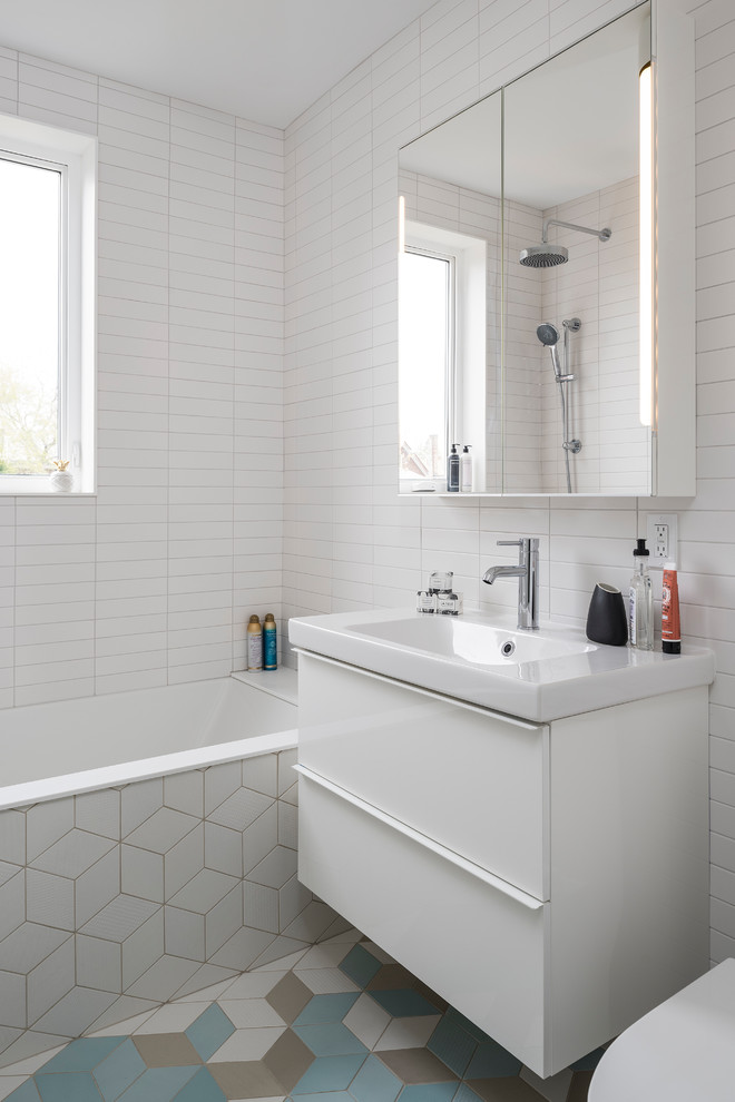 Свежая идея для дизайна: маленькая ванная комната в стиле модернизм с плоскими фасадами, белыми фасадами, накладной ванной, душем в нише, раздельным унитазом, белой плиткой, плиткой кабанчик, белыми стенами, полом из керамической плитки, душевой кабиной, подвесной раковиной, синим полом, открытым душем и белой столешницей для на участке и в саду - отличное фото интерьера