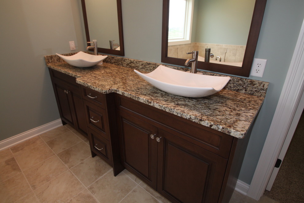 Large arts and crafts master brown tile and porcelain tile porcelain tile bathroom photo in Chicago with a vessel sink, raised-panel cabinets, dark wood cabinets, granite countertops, a two-piece toilet and blue walls