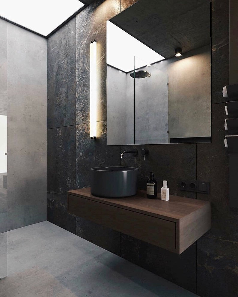 На фото: ванная комната в современном стиле с плоскими фасадами, темными деревянными фасадами, душем без бортиков, серой плиткой, серыми стенами, бетонным полом, настольной раковиной, столешницей из дерева, серым полом, открытым душем и коричневой столешницей с