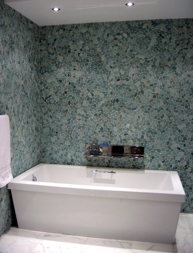 На фото: ванная комната с синей плиткой и галечной плиткой с