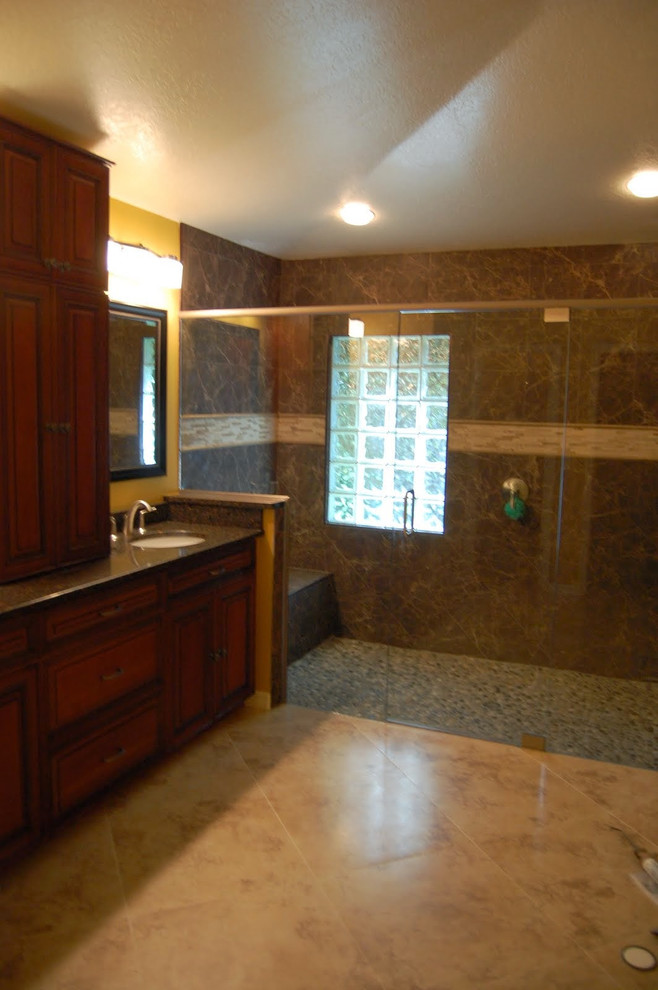 Cette photo montre une petite salle de bain principale méditerranéenne en bois foncé avec un lavabo encastré, un placard avec porte à panneau surélevé, un plan de toilette en granite, un carrelage multicolore, un mur jaune et un sol en marbre.