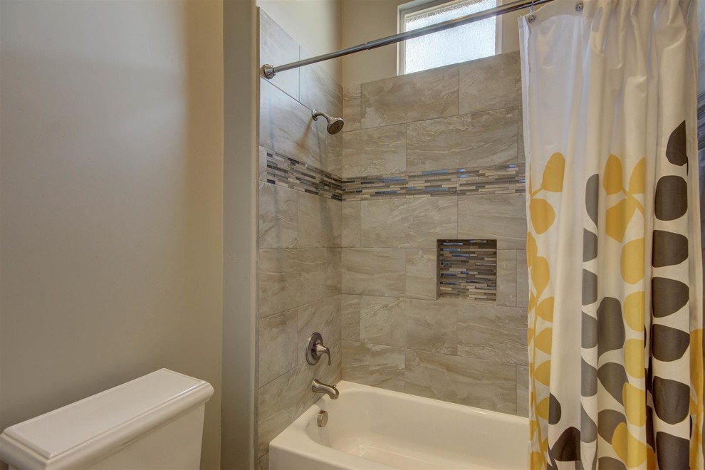 Inspiration for a medium sized traditional shower room bathroom in Phoenix with a corner bath, a shower/bath combination, a two-piece toilet, grey tiles, porcelain tiles, grey walls and medium hardwood flooring.