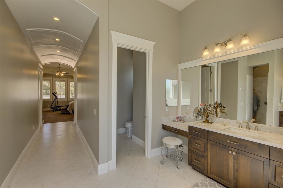 Inredning av ett klassiskt stort en-suite badrum, med luckor med infälld panel, skåp i mörkt trä, ett platsbyggt badkar, en hörndusch, grå kakel, vit kakel, stenkakel, grå väggar, marmorgolv, ett undermonterad handfat och marmorbänkskiva