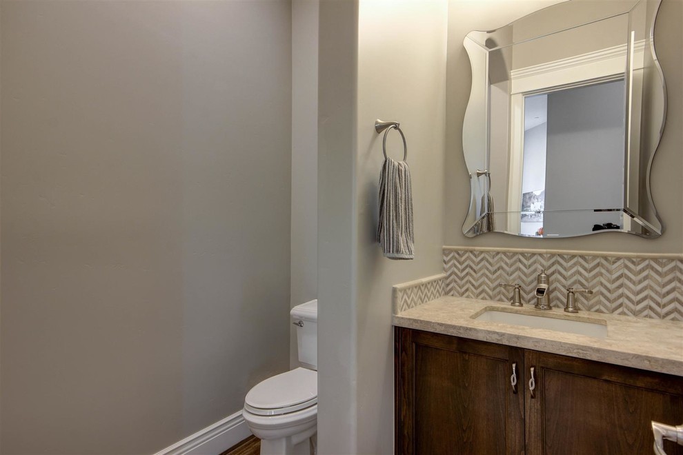 Bathroom - mid-sized transitional 3/4 beige tile and stone tile medium tone wood floor bathroom idea in Phoenix with recessed-panel cabinets, medium tone wood cabinets, a two-piece toilet, gray walls, an undermount sink and laminate countertops