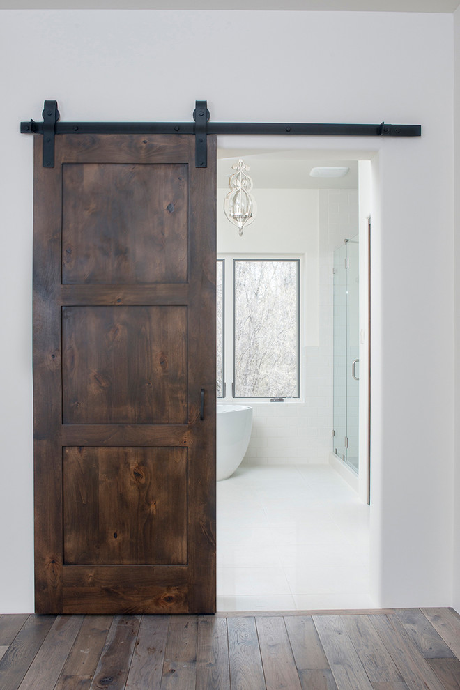 На фото: большая главная ванная комната в современном стиле с отдельно стоящей ванной, душем в нише, белыми стенами и полом из керамогранита с