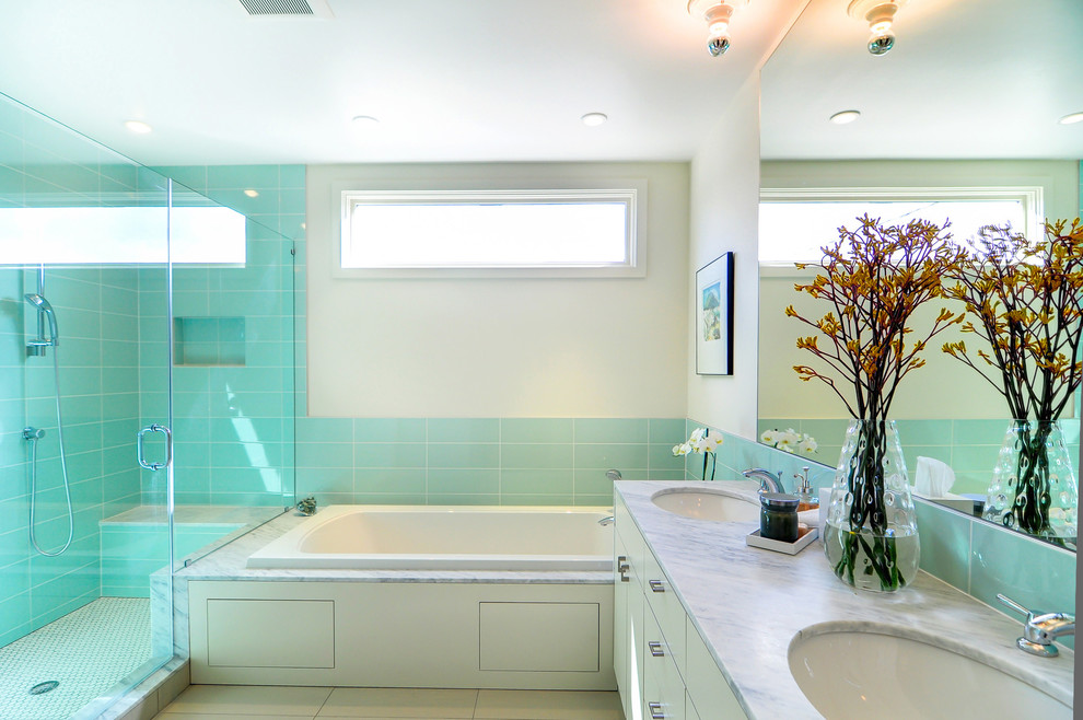 На фото: ванная комната в современном стиле с врезной раковиной, накладной ванной, угловым душем, унитазом-моноблоком, плоскими фасадами, бежевыми фасадами, мраморной столешницей, синей плиткой и керамической плиткой