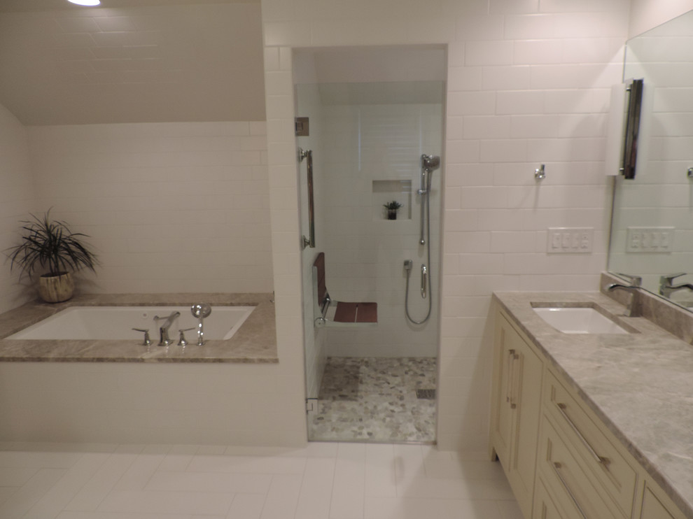 ローリーにある低価格の中くらいなトランジショナルスタイルのおしゃれなマスターバスルーム (シェーカースタイル扉のキャビネット、ベージュのキャビネット、アンダーマウント型浴槽、バリアフリー、分離型トイレ、白いタイル、セラミックタイル、白い壁、セラミックタイルの床、アンダーカウンター洗面器、珪岩の洗面台、白い床、開き戸のシャワー) の写真