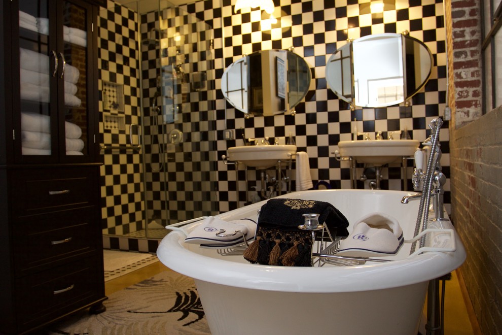 Cette image montre une petite salle de bain principale urbaine avec une baignoire indépendante, une douche d'angle, un carrelage noir et blanc, des carreaux de céramique, un mur multicolore, sol en béton ciré, un plan vasque, un sol beige et une cabine de douche à porte battante.