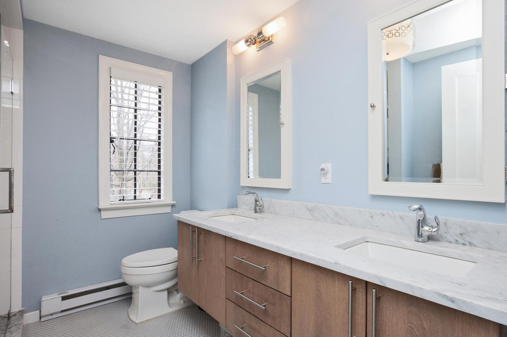 Exemple d'une salle de bain sud-ouest américain de taille moyenne avec un placard à porte plane, des portes de placard marrons, une douche d'angle, WC séparés, un mur bleu, un sol en carrelage de porcelaine, un lavabo encastré, un plan de toilette en marbre, un sol gris et une cabine de douche à porte battante.