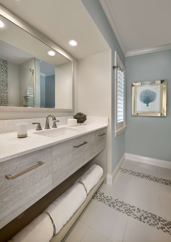 Idee per una stanza da bagno padronale stile marinaro di medie dimensioni con ante lisce, ante in legno chiaro, pareti blu, lavabo sottopiano, top in laminato e pavimento con piastrelle in ceramica