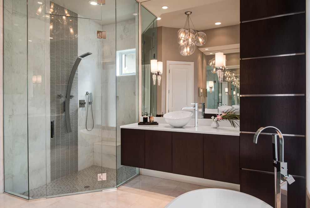 На фото: большая ванная комната: освещение в современном стиле с настольной раковиной, плоскими фасадами, темными деревянными фасадами, отдельно стоящей ванной, душем в нише и серыми стенами с
