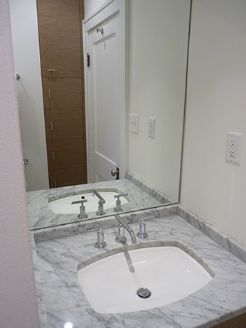 Esempio di una piccola stanza da bagno moderna con lavabo sottopiano, ante lisce, ante in legno scuro, top in marmo, vasca ad alcova, vasca/doccia, WC monopezzo, piastrelle bianche, piastrelle in ceramica, pareti bianche e pavimento in marmo