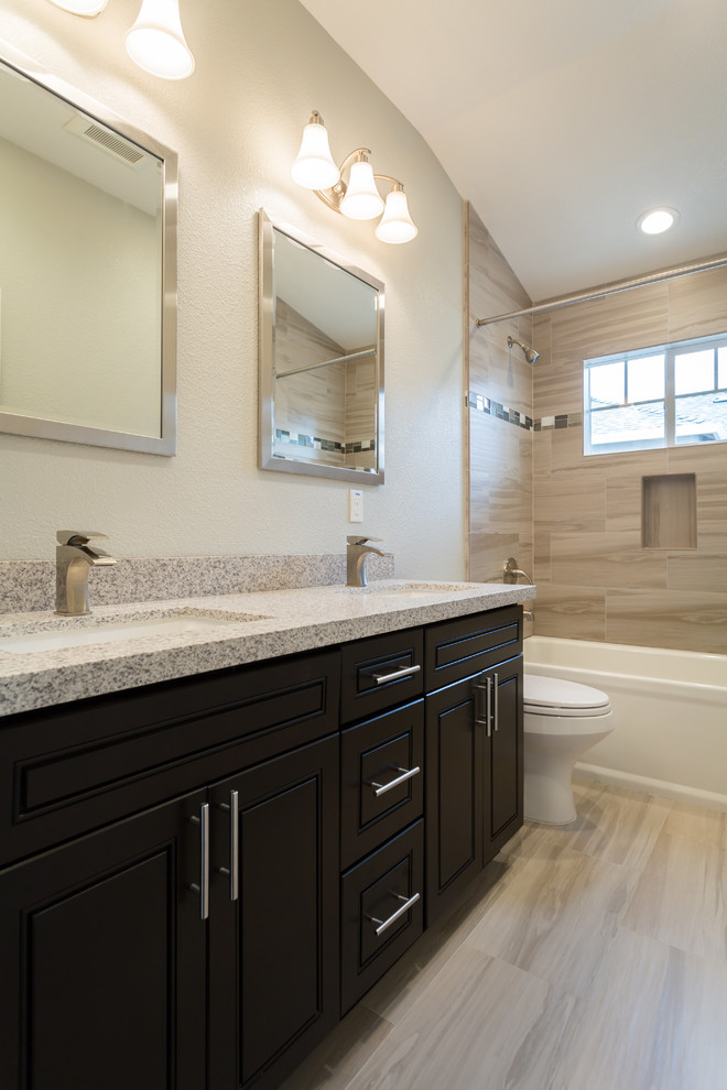 This is an example of a medium sized contemporary ensuite bathroom in Phoenix with raised-panel cabinets, dark wood cabinets, an alcove bath, a shower/bath combination, beige tiles, porcelain tiles, porcelain flooring, a submerged sink, laminate worktops, beige walls, a one-piece toilet, beige floors and a shower curtain.