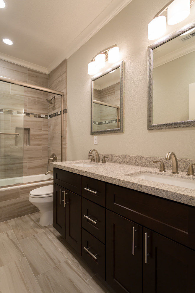Bathroom - mid-sized transitional master beige tile and porcelain tile porcelain tile and beige floor bathroom idea in San Diego with raised-panel cabinets, dark wood cabinets, beige walls, an undermount sink, laminate countertops and a one-piece toilet