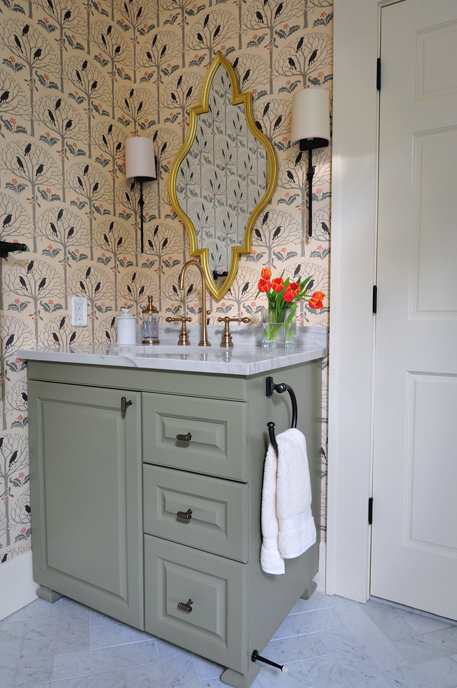 Klassisk inredning av ett stort en-suite badrum, med ett undermonterad handfat, luckor med upphöjd panel, gröna skåp, bänkskiva i kvartsit, ett fristående badkar, vit kakel och marmorgolv
