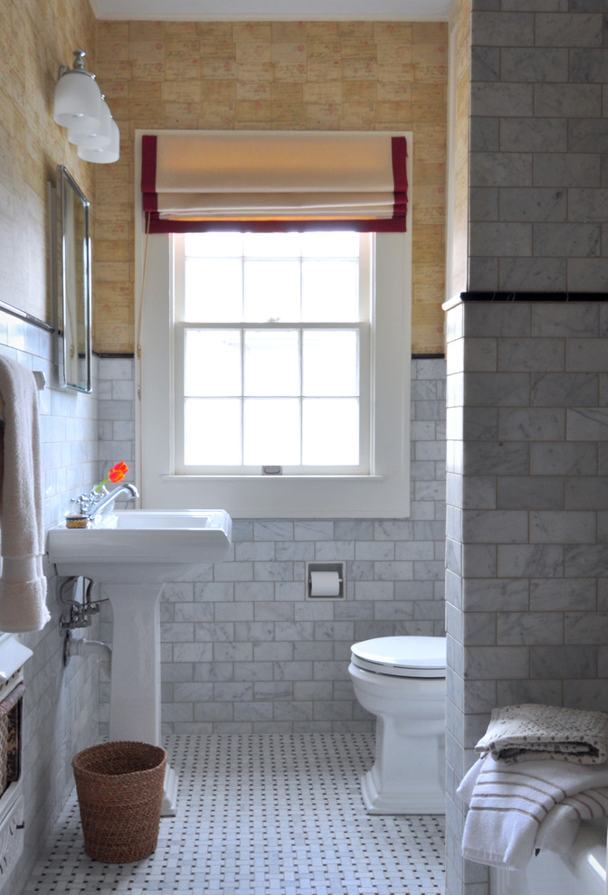 Idee per una stanza da bagno classica di medie dimensioni con lavabo a colonna, vasca ad alcova, vasca/doccia, piastrelle bianche, piastrelle in pietra e pavimento in marmo
