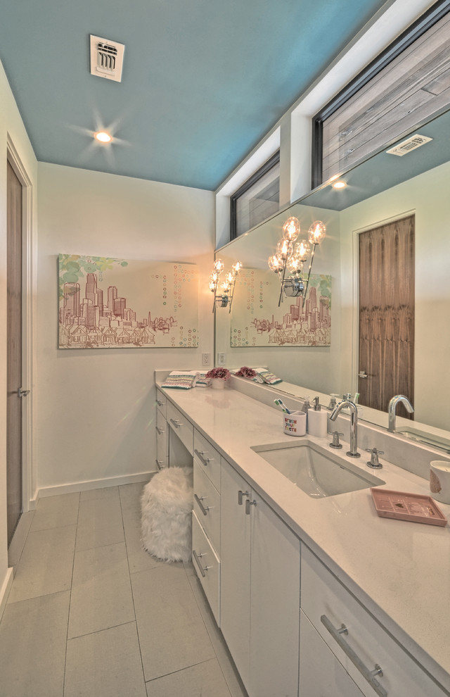 Modern inredning av ett stort badrum med dusch, med släta luckor, vita skåp, vita väggar, klinkergolv i porslin, ett undermonterad handfat, bänkskiva i kvarts och grått golv