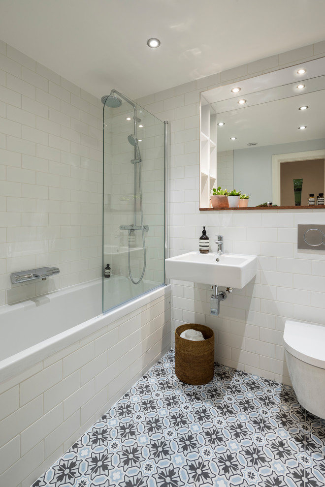 Foto di una stanza da bagno bohémian di medie dimensioni con vasca/doccia, WC sospeso, pareti bianche, pavimento in cementine, lavabo sospeso, pavimento multicolore e porta doccia a battente