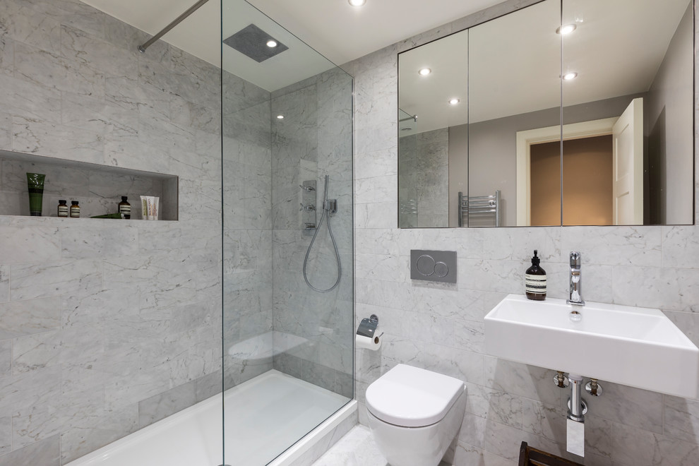 Idee per una stanza da bagno contemporanea di medie dimensioni con ante lisce, doccia aperta, WC sospeso, piastrelle di marmo, pareti bianche, pavimento in marmo, lavabo sospeso, pavimento grigio e doccia aperta