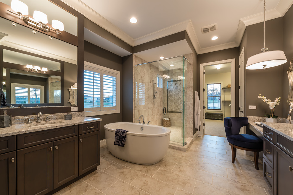 This is an example of a large classic ensuite bathroom in Cincinnati with recessed-panel cabinets, medium wood cabinets, a freestanding bath, a corner shower, beige tiles, porcelain tiles, porcelain flooring, a submerged sink, granite worktops, brown walls and beige floors.