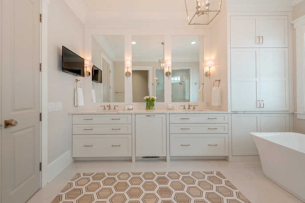 Example of a beach style white floor freestanding bathtub design in Charlotte with shaker cabinets, white cabinets, white walls, an undermount sink and white countertops