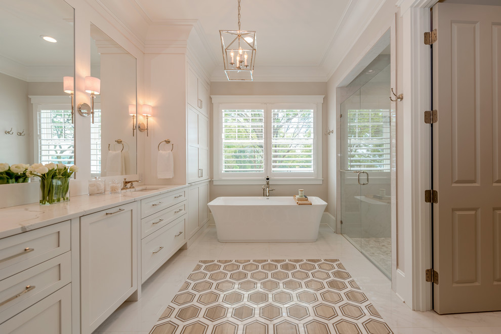 Inspiration for a beach style bathroom in Charlotte with shaker cabinets, white cabinets, a freestanding bath, grey walls, a submerged sink, white floors and white worktops.