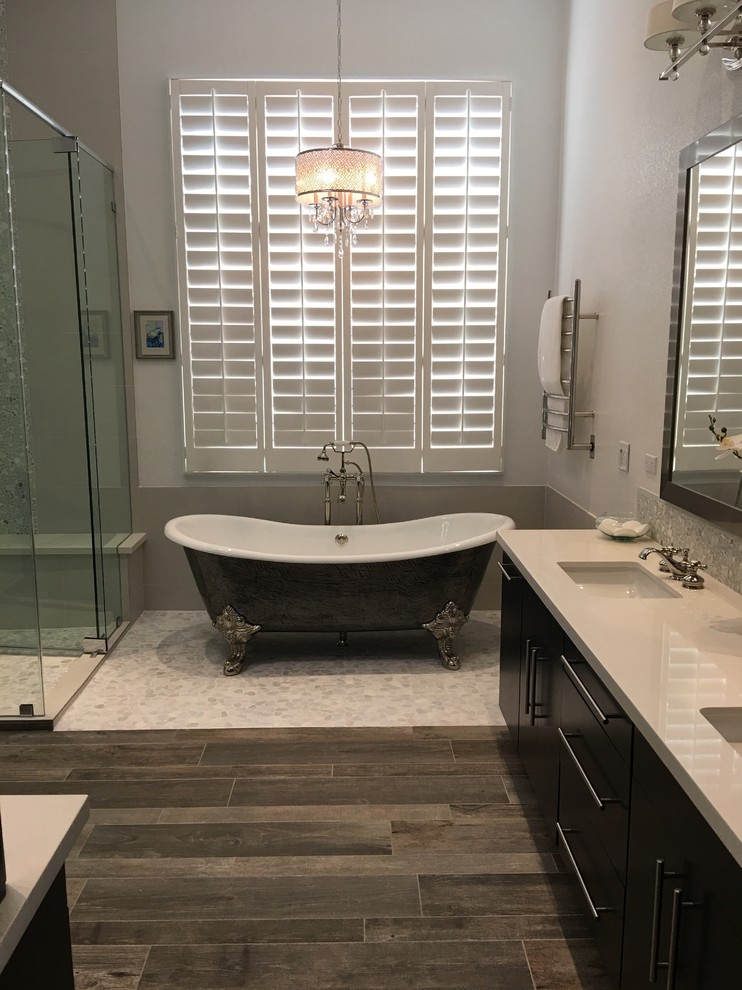 Example of a large transitional master dark wood floor and brown floor bathroom design in Tampa with flat-panel cabinets, black cabinets, gray walls, an undermount sink, quartz countertops and a hinged shower door