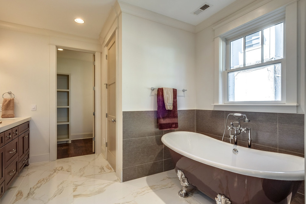 Inspiration for a large classic ensuite bathroom in Tampa with shaker cabinets, dark wood cabinets, a claw-foot bath, brown tiles, porcelain tiles, white walls, marble flooring, a submerged sink, engineered stone worktops and beige floors.