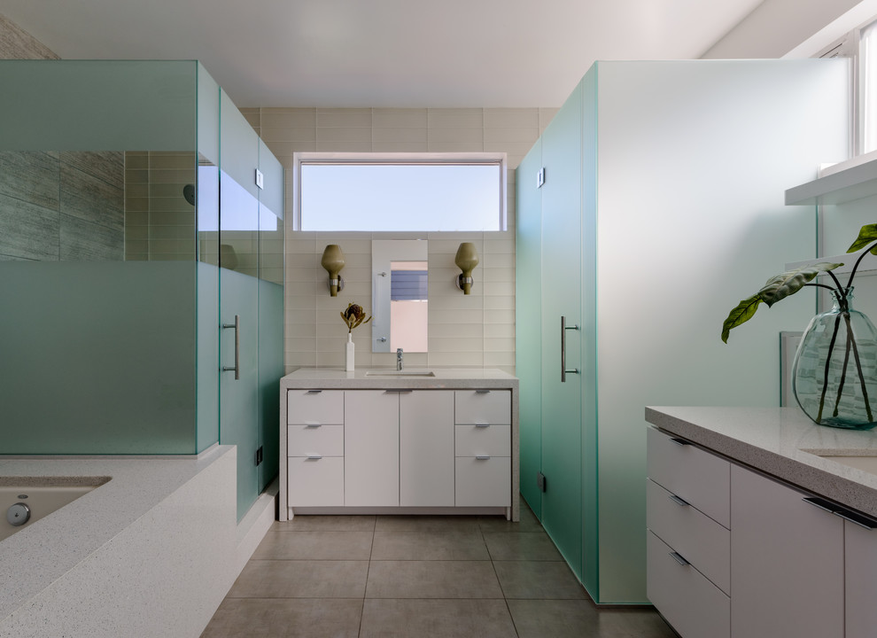 Esempio di una stanza da bagno design con lavabo sottopiano, ante lisce, ante bianche, vasca sottopiano, doccia alcova e piastrelle bianche