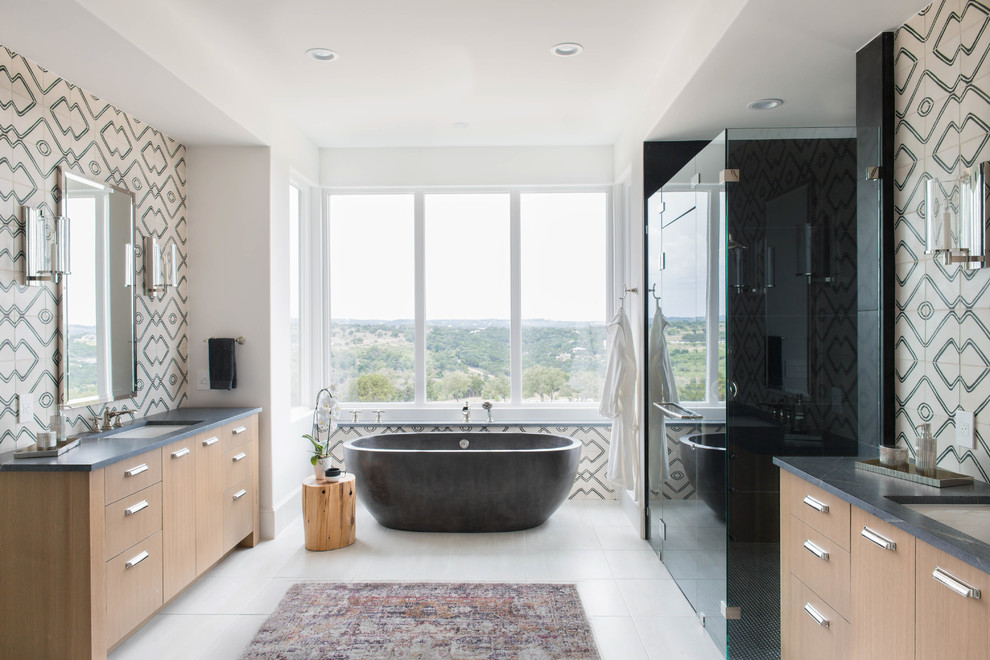 This is an example of a classic ensuite bathroom in Austin with flat-panel cabinets, brown cabinets, a freestanding bath, an alcove shower, black tiles, multi-coloured walls, a submerged sink, white floors and a hinged door.