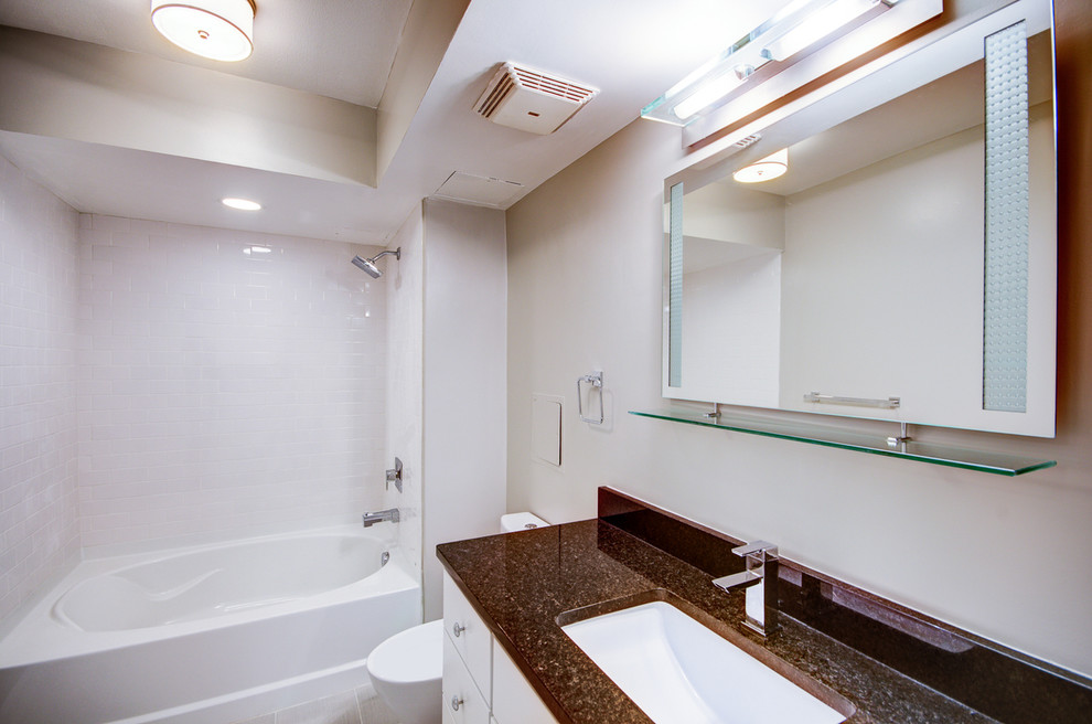 На фото: ванная комната среднего размера в современном стиле с фасадами в стиле шейкер, белыми фасадами, ванной в нише, душем над ванной, белой плиткой, плиткой кабанчик, бежевыми стенами, полом из керамической плитки, врезной раковиной и столешницей из гранита