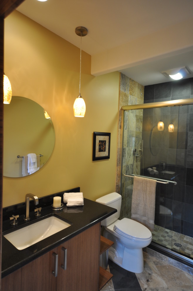 Example of a large trendy 3/4 gray tile and stone tile slate floor alcove shower design in Philadelphia with an undermount sink, flat-panel cabinets, brown cabinets, granite countertops, a two-piece toilet and yellow walls