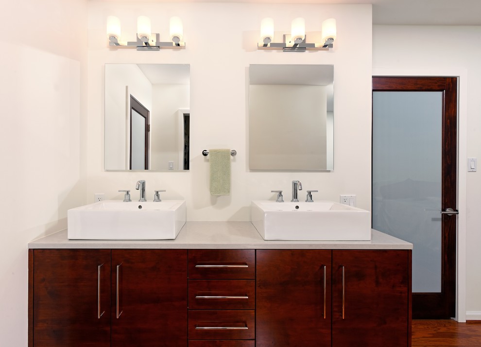Пример оригинального дизайна: большая главная ванная комната в современном стиле с плоскими фасадами, темными деревянными фасадами, белыми стенами, паркетным полом среднего тона, настольной раковиной, столешницей из искусственного кварца и раздельным унитазом