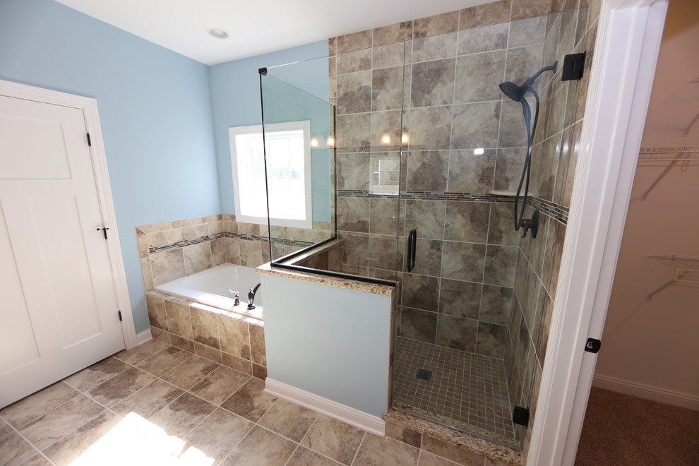 Foto på ett mellanstort amerikanskt en-suite badrum, med blå väggar, ett undermonterad handfat, granitbänkskiva, luckor med infälld panel, skåp i mörkt trä, ett badkar i en alkov, en hörndusch, beige kakel, porslinskakel och klinkergolv i porslin