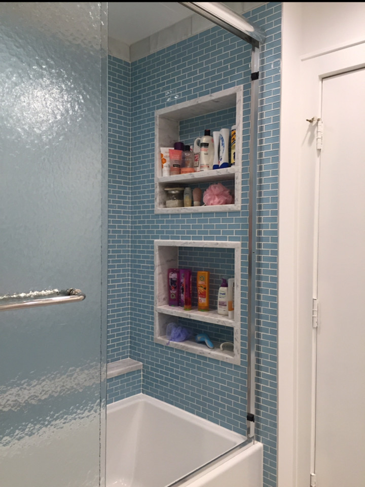 Immagine di una stanza da bagno contemporanea di medie dimensioni con ante con riquadro incassato, ante bianche, vasca ad alcova, vasca/doccia, piastrelle blu, piastrelle di vetro, pareti bianche e top in quarzite