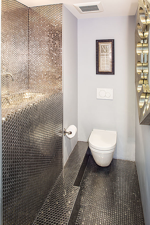 Immagine di una stanza da bagno moderna con WC sospeso, piastrelle grigie, piastrelle in metallo, pareti grigie e pavimento con piastrelle a mosaico
