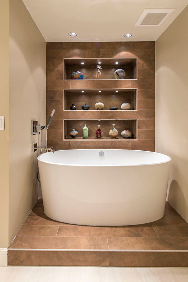 Imagen de cuarto de baño principal contemporáneo grande con bañera exenta, paredes beige y suelo de baldosas de porcelana