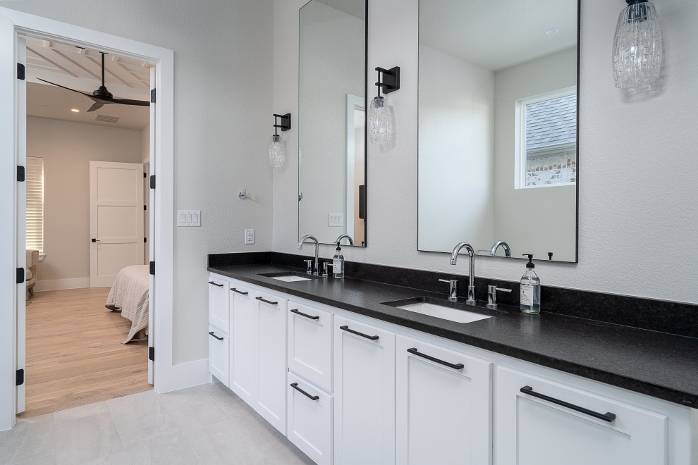 Immagine di una stanza da bagno padronale scandinava di medie dimensioni con ante bianche, pareti bianche, pavimento in cementine, lavabo da incasso, top in granito, pavimento beige, top nero, due lavabi e mobile bagno incassato