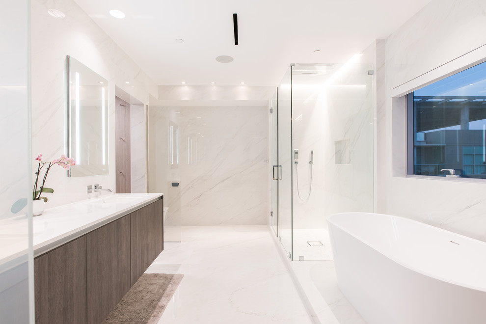 Exemple d'une salle de bain principale tendance en bois foncé avec un placard à porte plane, une baignoire indépendante, une douche d'angle, un carrelage blanc, du carrelage en marbre, un mur blanc, un sol en marbre, un plan vasque, un sol blanc, une cabine de douche à porte battante et un plan de toilette blanc.