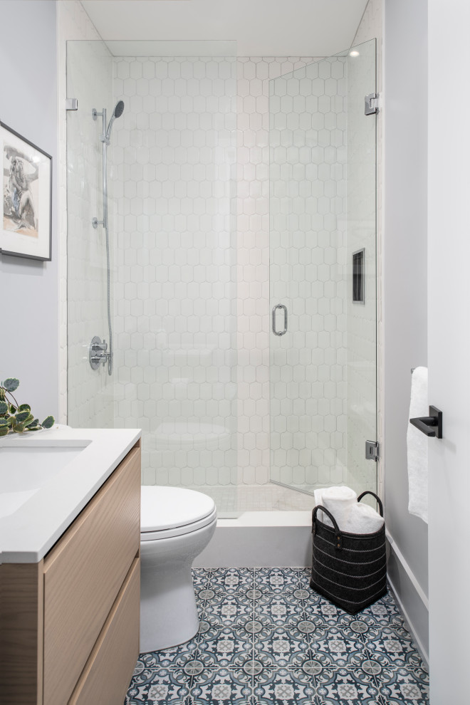 Inspiration för ett mellanstort minimalistiskt vit vitt badrum med dusch, med släta luckor, skåp i ljust trä, ett undermonterat badkar, en dusch i en alkov, en toalettstol med hel cisternkåpa, vit kakel, keramikplattor, grå väggar, klinkergolv i keramik, ett undermonterad handfat, träbänkskiva och dusch med gångjärnsdörr