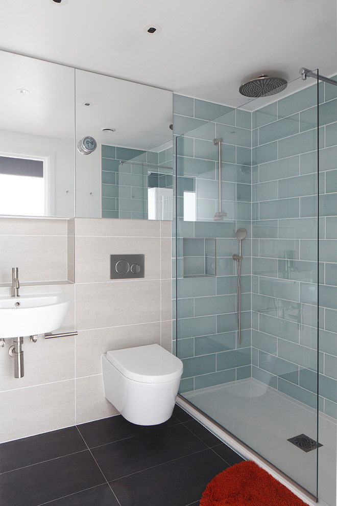 Ejemplo de cuarto de baño actual con ducha abierta, sanitario de pared y aseo y ducha
