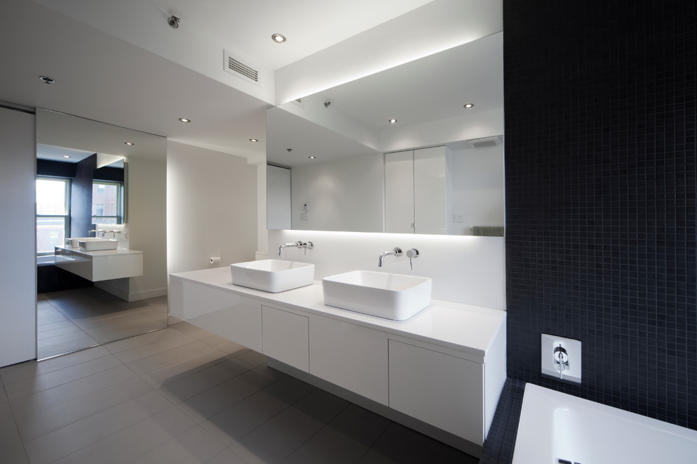 Diseño de cuarto de baño rectangular contemporáneo con baldosas y/o azulejos en mosaico, lavabo sobreencimera y espejo con luz