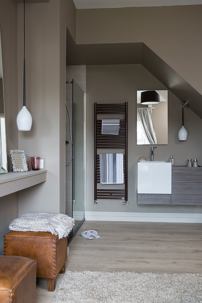 Modelo de cuarto de baño contemporáneo de tamaño medio con armarios con paneles lisos, puertas de armario grises, ducha abierta, paredes grises, lavabo suspendido, suelo gris y ducha abierta