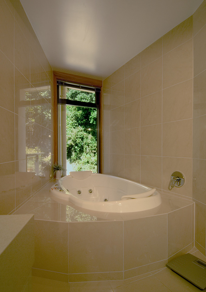 Cette photo montre une salle de bain tendance avec une baignoire posée et un carrelage beige.
